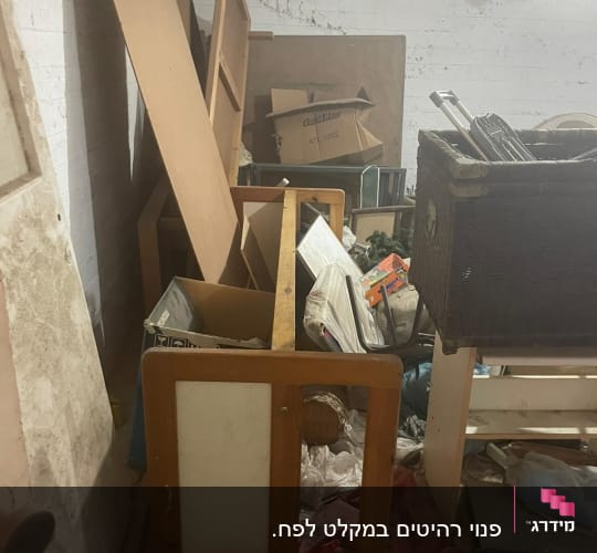 חדר עמוס בחפצים, קרטונים ורהיטים ישנים